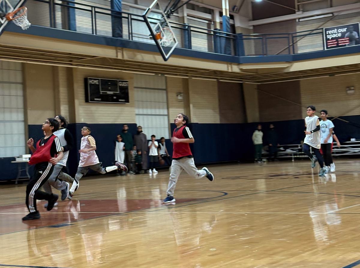 Kids sprinting down the court toward the basket.